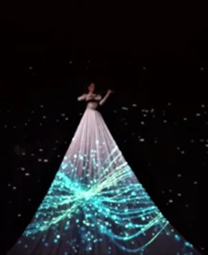 Aerial violinist suspended above the stage, light projected onto her long gown