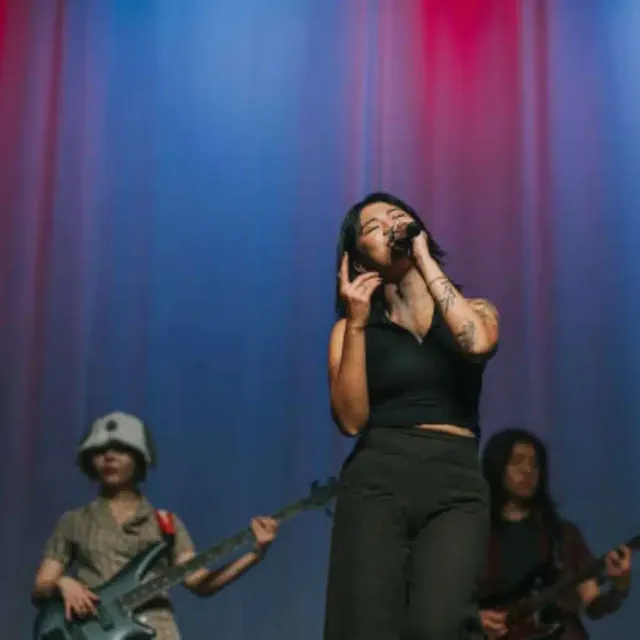 Chinese band with a female singer and guitarists on stage