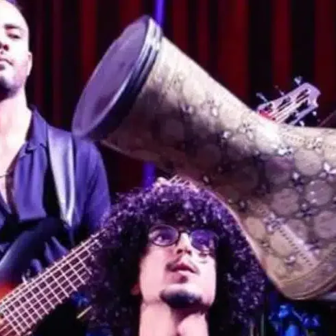 Drummer with a darbuka performing on stage beside a bassist
