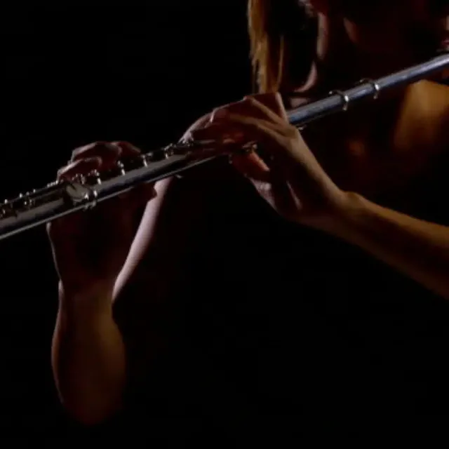 Female jazz flautist playing in low light