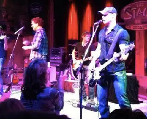 Live band performing on a stage with guitars and vocals
