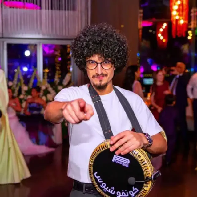 Percussionist holding a decorated darbuka at a party