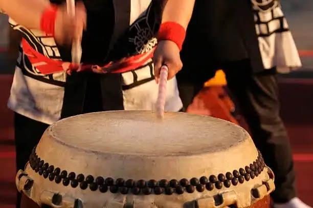 Taiko drummer striking a large Japanese drum